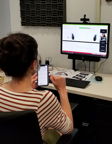 Student using an app to allow for remote programming of hearing aids