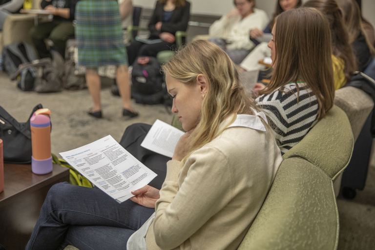 A student looks over a paper handout