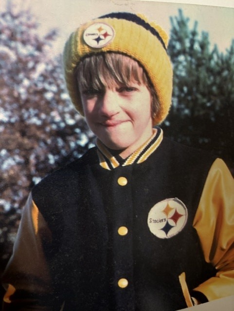 A young Douglas Burrows smiling in his Steelers gear.