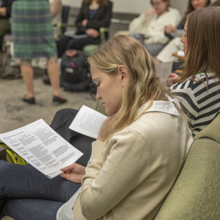 A student looks over a paper handout