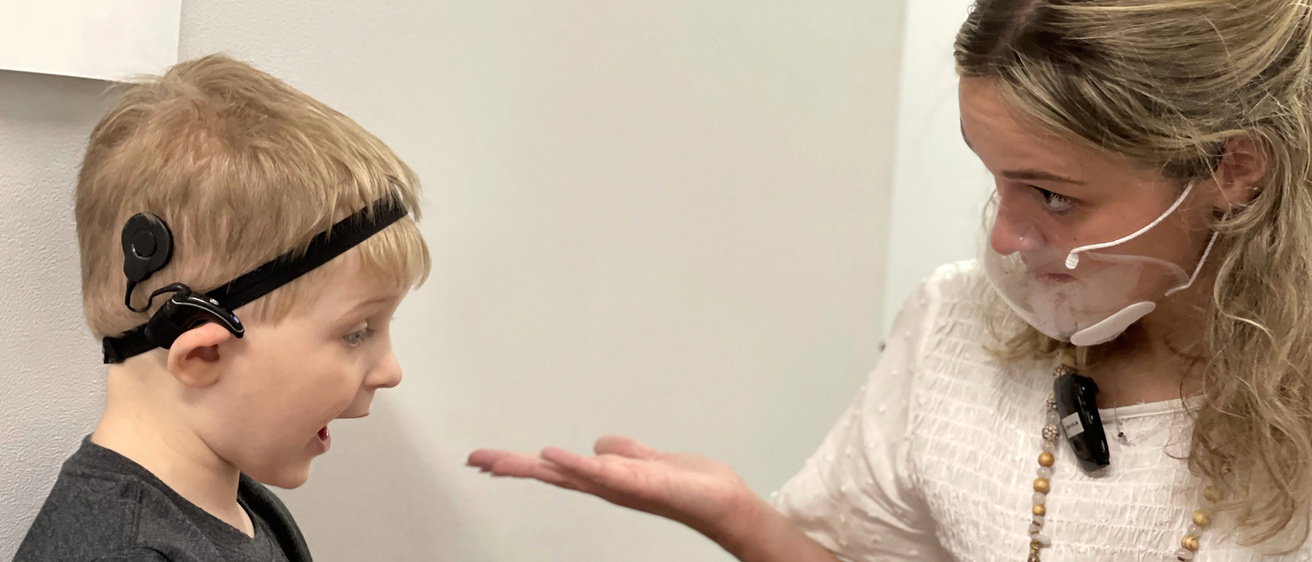 grad clinician providing therapy to boy with cochlear implant