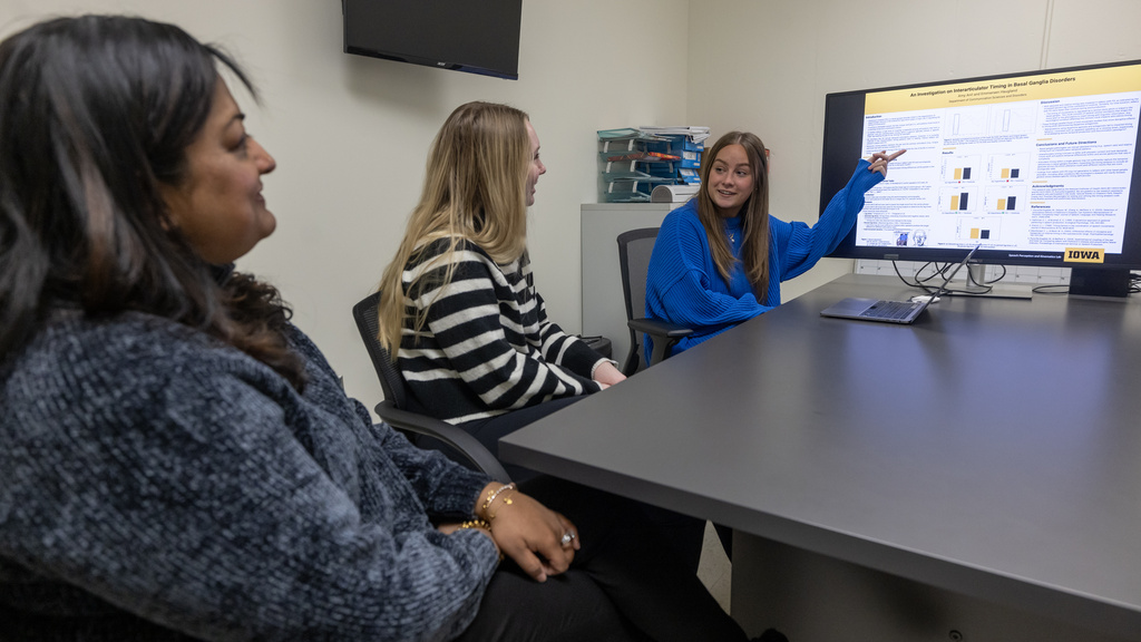 Mili Kuruvilla-Dugdale sitting with students in a classroom.