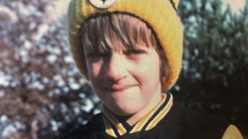 A young Douglas Burrows smiling in his Steelers gear.